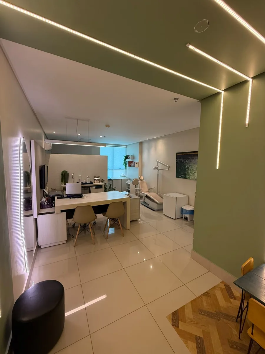 Sala de atendimento adulto, com parede verde, mesa e cadeira de atendimento